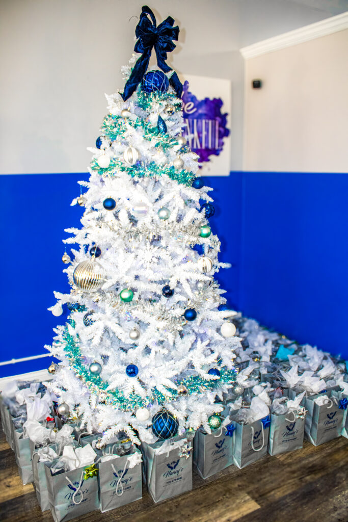 White Christmas tree with blue decorations and gifts.