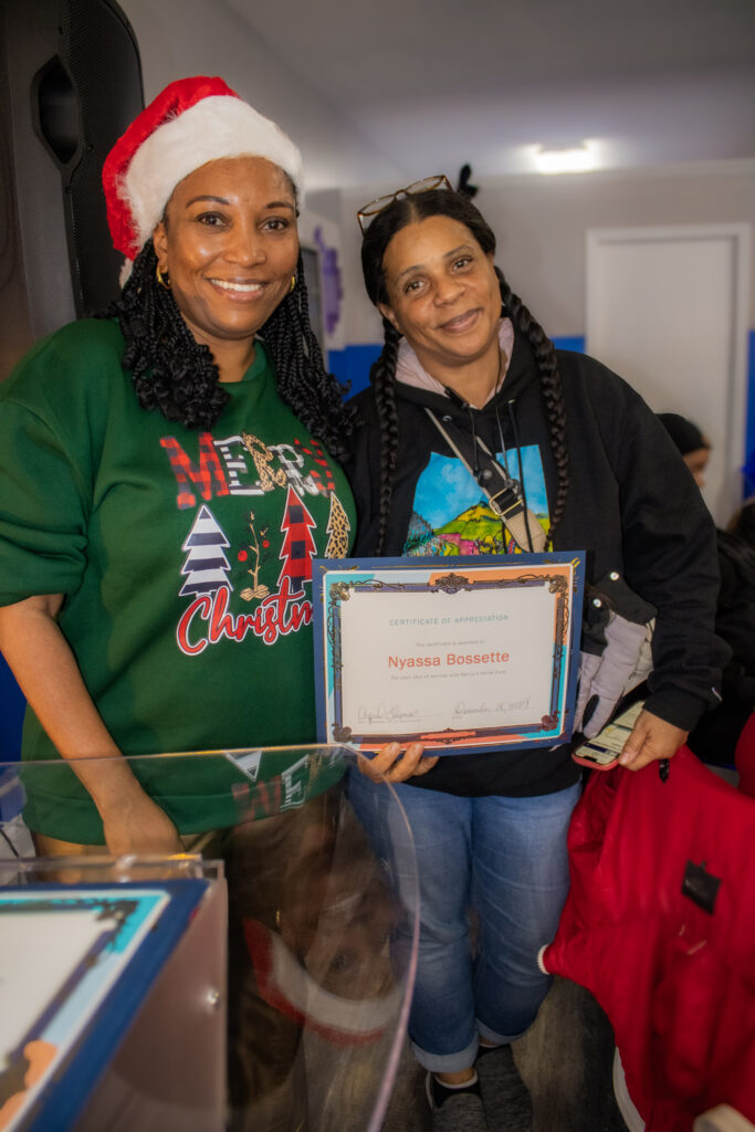 Two women holding a certificate of appreciation.