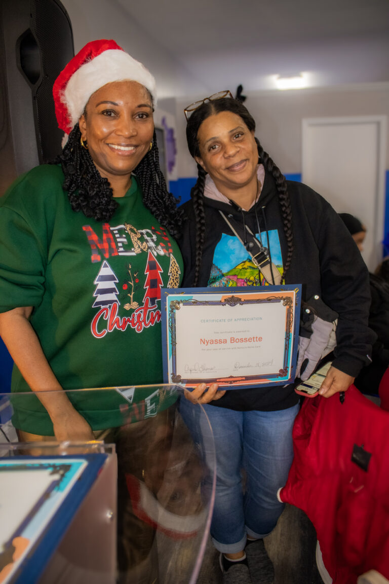 Two women holding a certificate of appreciation.