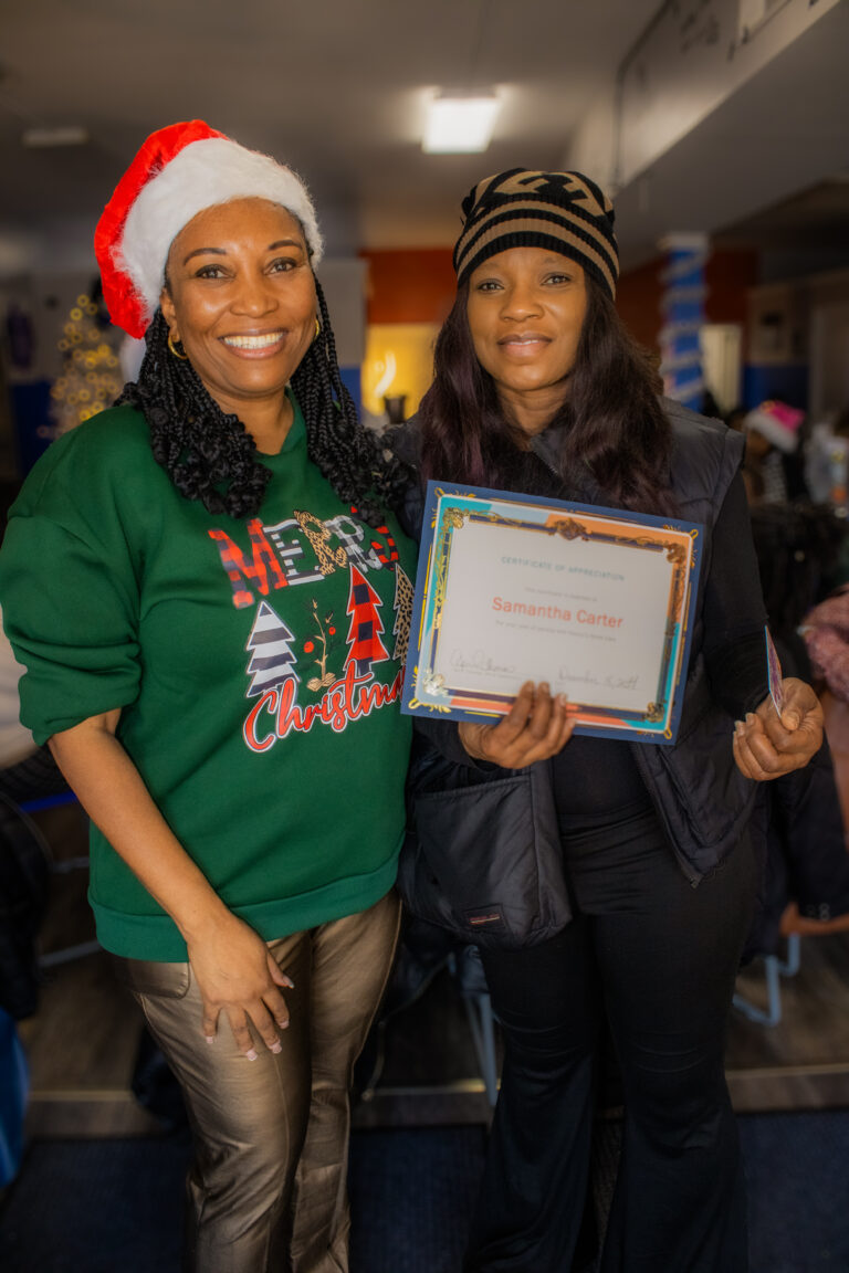 Two women celebrating with a certificate.