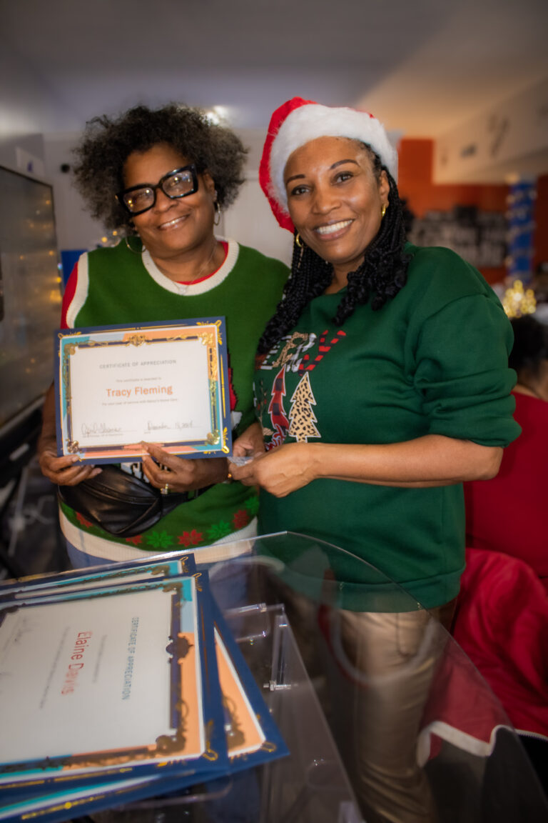 Two women holding a certificate of appreciation.